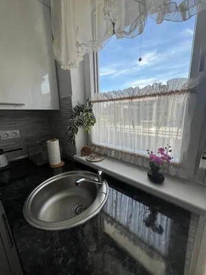 a bathroom with a sink and a window with flowers at Apartman Jan in Bihać