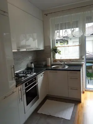a kitchen with white cabinets and a sink and a stove at Apartman Jan in Bihać
