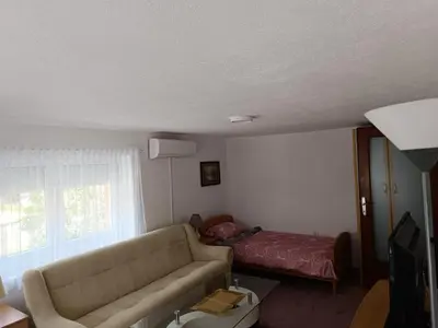 a living room with a couch and a bed at Kuća za odmor Majka in Fojnica