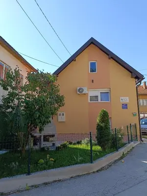 a yellow house with a fence in front of it at Kuća za odmor Majka in Fojnica