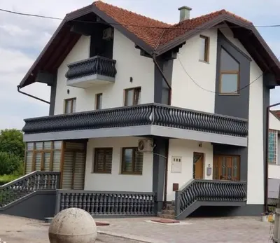 a large white house with a brown roof at Teal Apartment 1 in Bihać