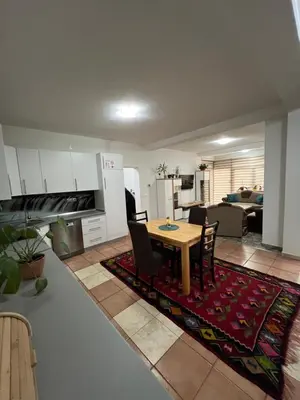 a kitchen and living room with a table and chairs at Teal Apartment 1 in Bihać