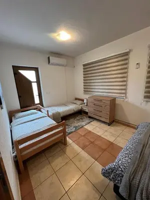 a room with two beds and a cabinet and a window at Teal Apartment 1 in Bihać