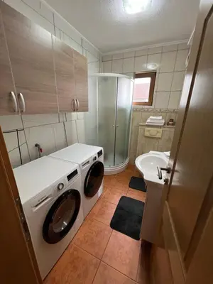 a bathroom with a washing machine and a sink at Teal Apartment 2 in Bihać