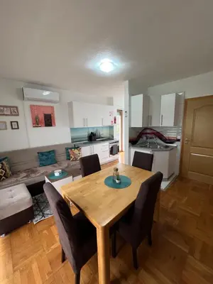 a kitchen and a dining room with a table and chairs at Teal Apartment 2 in Bihać