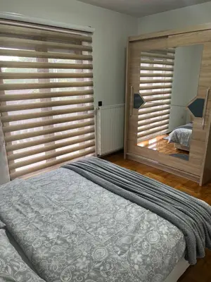 a bedroom with a large bed and a large window at Teal Apartment 2 in Bihać