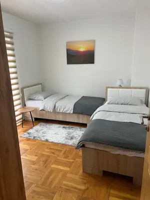 a bedroom with two beds and a painting on the wall at Teal Apartment 2 in Bihać