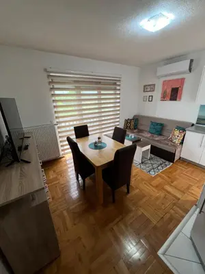 a living room with a table and chairs and a couch at Teal Apartment 2 in Bihać