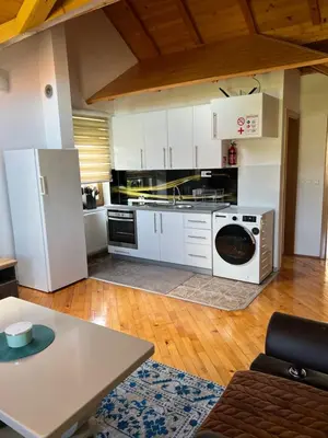 a kitchen with a refrigerator and a washer and dryer at Teal Apartment 3 in Bihać