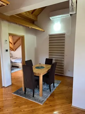 a dining room with a wooden table and chairs at Teal Apartment 3 in Bihać