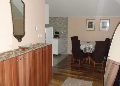a kitchen and dining room with a table and a mirror at Apartments A&D in Bihać