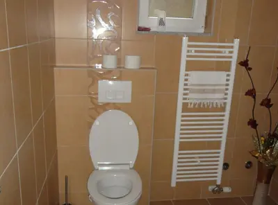 a bathroom with a toilet with a shelf and a window at Apartments A&D in Bihać