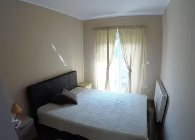 a bedroom with a bed and a large window at Apartments A&D in Bihać