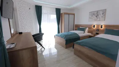 a hotel room with two beds and a desk at Belvedere rooms A&E in Velika Kladuša