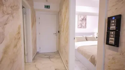 a bedroom with a bed and a wall with marble at Belvedere rooms A&E in Velika Kladuša