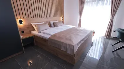 a bedroom with a bed and a chair and a window at Belvedere rooms A&E in Velika Kladuša