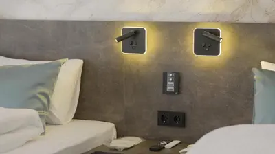 a bedroom with two beds and two monitors on the wall at Belvedere rooms A&E in Velika Kladuša