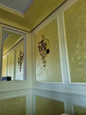 a wall with two mirrors and a chandelier on it at Apartman Spa kristal in Banja Luka