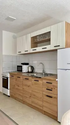 a kitchen with wooden cabinets and white appliances at Apartment Diletta in Banja Luka
