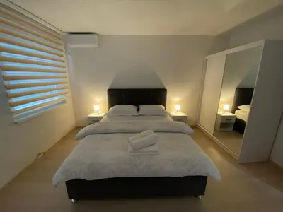 a bedroom with a large bed and a mirror at Apartment Diletta in Banja Luka
