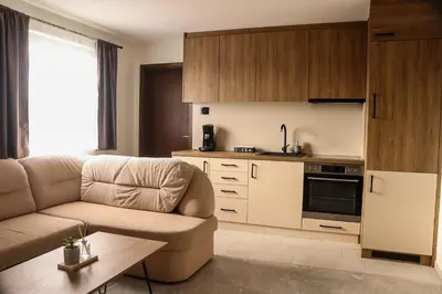a living room with a couch and a kitchen at Tesla Apartman Prnjavor in Prnjavor