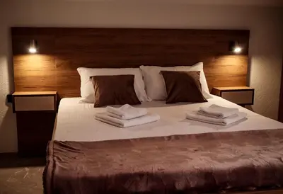 a bedroom with a large bed with towels on it at Tesla Apartman Prnjavor in Prnjavor