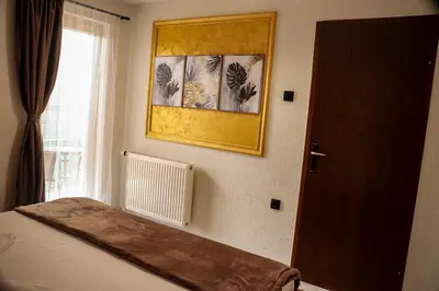 a bedroom with a bed and a picture on the wall at Tesla Apartman Prnjavor in Prnjavor