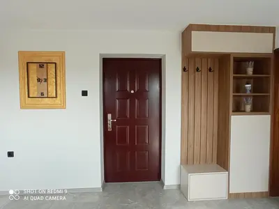 a room with a brown door and a shelf at Tesla Apartman Prnjavor in Prnjavor