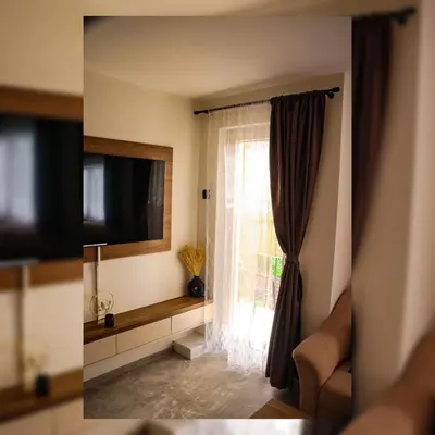 a living room with a window and a television at Tesla Apartman Prnjavor in Prnjavor