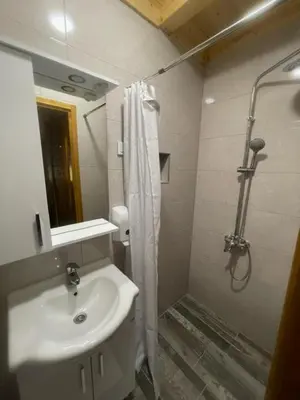 a bathroom with a sink and a shower with a shower curtain at Etno zona Oaza mira in Donji Vakuf