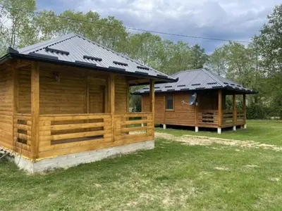 two wooden houses with solar panels on top of them at Etno zona Oaza mira in Donji Vakuf