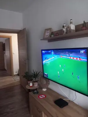 a flat screen tv hanging on a wall in a living room at Apartman DEA in Bihać