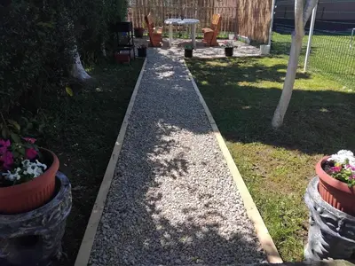 a walkway in a yard with potted plants at Studio apartman Nejra in Bihać