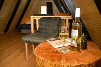 a bottle of wine and a glass on a table at Cottage NIKA in Jajce