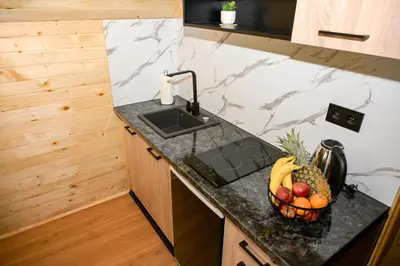 a kitchen with a sink and a fruit basket on a counter at Cottage NIKA in Jajce