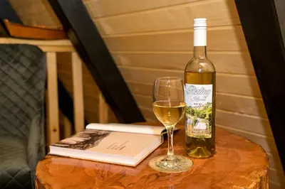 a bottle of wine and a glass on a table at Cottage NIKA in Jajce