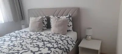a bed with blue and white sheets and pillows at Nela Bl in Banja Luka