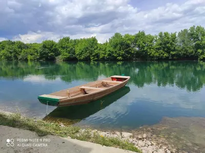 a small wooden boat sitting on the water at Vila Didan-apartmani in Bihać