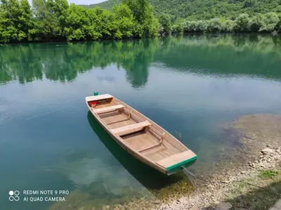 a small wooden boat sitting on the water at Vila Didan-apartmani in Bihać
