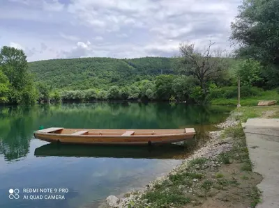 a wooden boat sitting in the middle of a river at Vila Didan-apartmani in Bihać