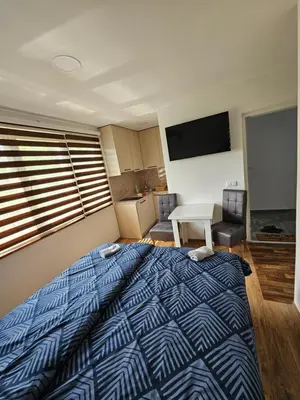 a bedroom with a bed with a blue and white comforter at Apartmani gradina Tuzla in Tuzla