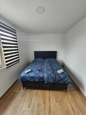 a bedroom with a bed and a wooden floor at Apartmani gradina Tuzla in Tuzla