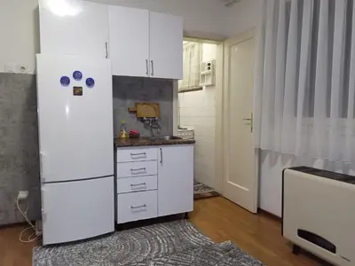 a kitchen with white cabinets and a refrigerator at Apartment KARO in Visoko