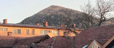 a group of roofs of houses with a mountain in the background at Apartment KARO in Visoko