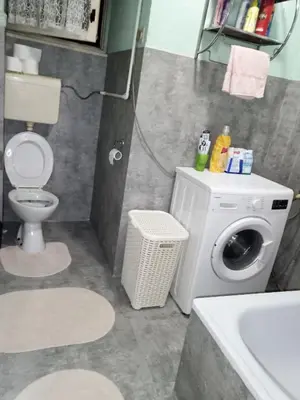 a bathroom with a washing machine and a sink at Apartment KARO in Visoko