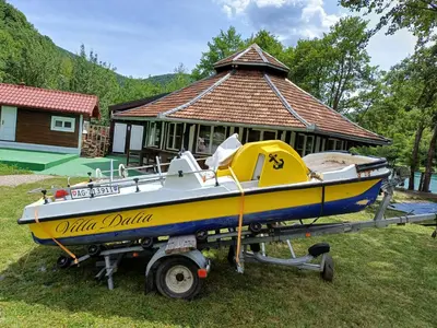 a yellow and blue boat on a trailer in front of a house at Holiday house 