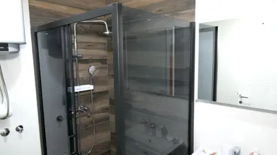 a shower with a glass door in a bathroom at Kuća za odmor GAVRIĆ in Mrkonjić Grad