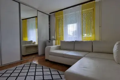 a living room with a white couch and some windows at Apartman Nataša BL 2 in Banja Luka
