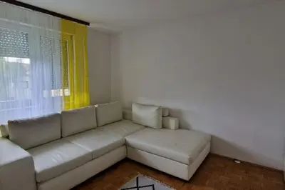a living room with a white couch and a window at Apartman Nataša BL 2 in Banja Luka