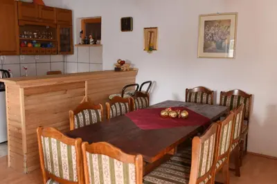 a dining room with a wooden table and chairs at Brano in Kupres